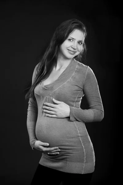 Όμορφη έγκυος γυναίκα σε ένα γκρι φόρεμα — Φωτογραφία Αρχείου