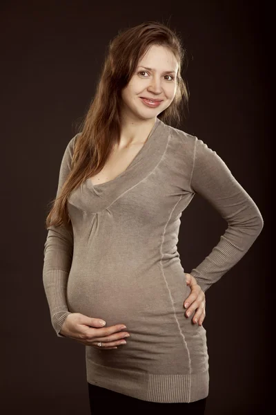 Mulher grávida bonita em um vestido cinza — Fotografia de Stock