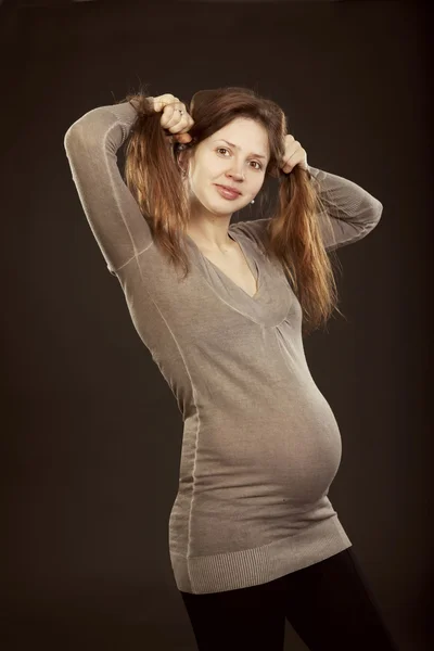Piękna kobieta w ciąży w szarej sukience — Zdjęcie stockowe