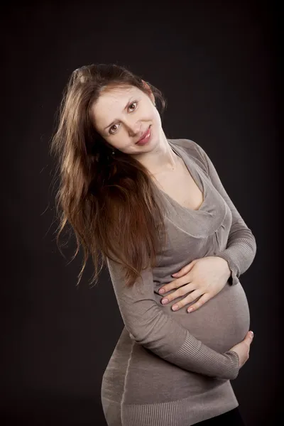 회색 드레스를 입고 아름 다운 임신한 여자 — 스톡 사진