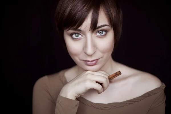 Девушка с макияжем в оттенках коричневого и корицы в руке — стоковое фото