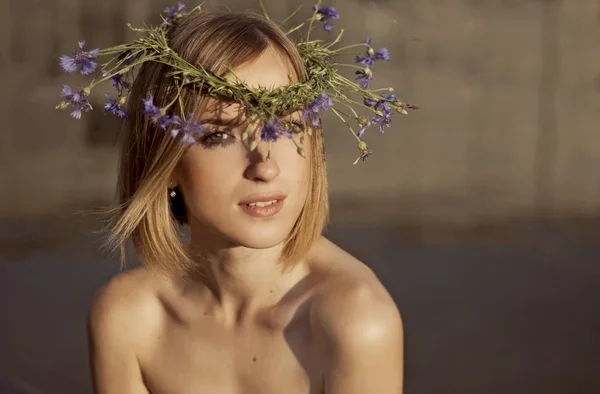 Menina bonita com uma coroa de flores de milho em seu cabelo — Fotografia de Stock
