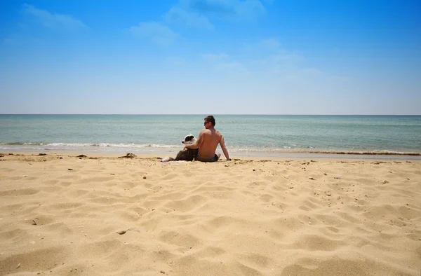 Homem com cão em uma praia — Fotografia de Stock
