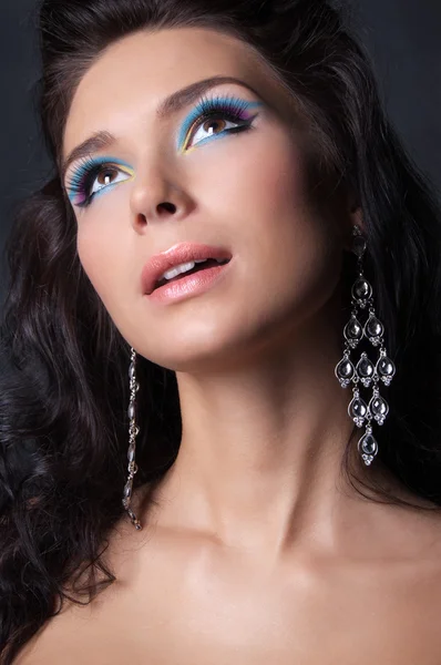 Frau mit professionellem farbenfrohen Make-up und Ohrringen — Stockfoto