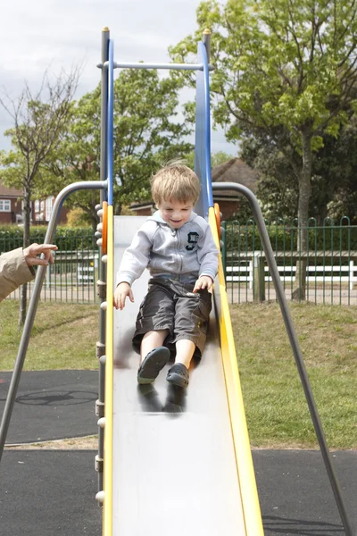Little boy sliding down a slide — Stock Photo, Image