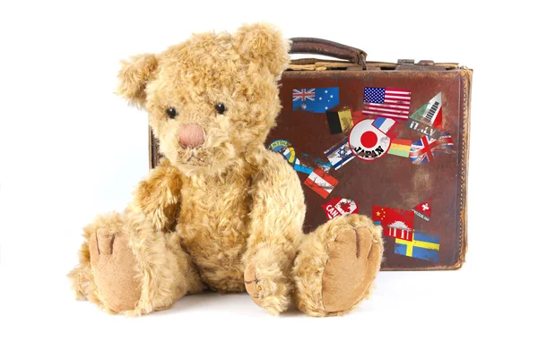 Teddybär und alter Koffer mit Weltaufklebern — Stockfoto
