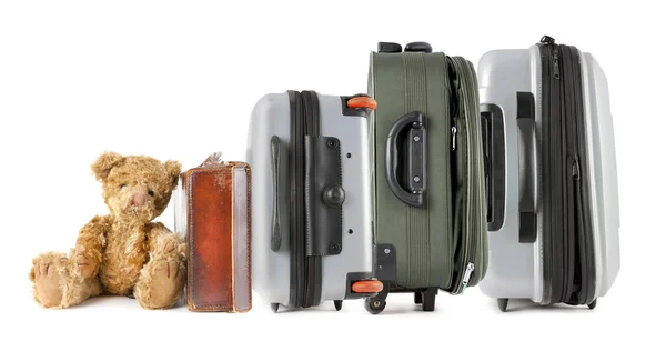 Row of suitcases with teddy bear sitting at the end — Stock Photo, Image