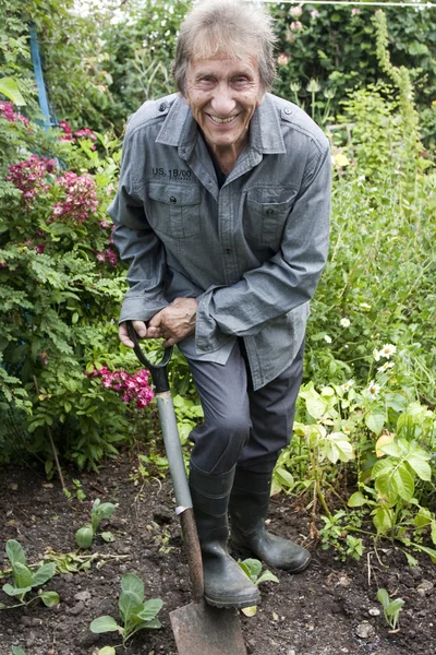 Uomo giardinaggio e sorridente alla macchina fotografica — Foto Stock