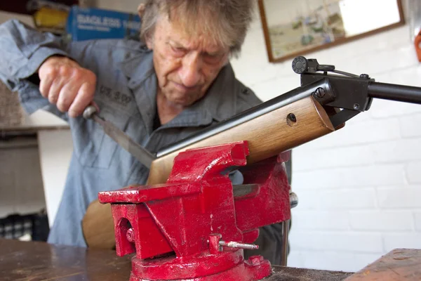 Mann repariert Waffe in seiner Werkstatt — Stockfoto