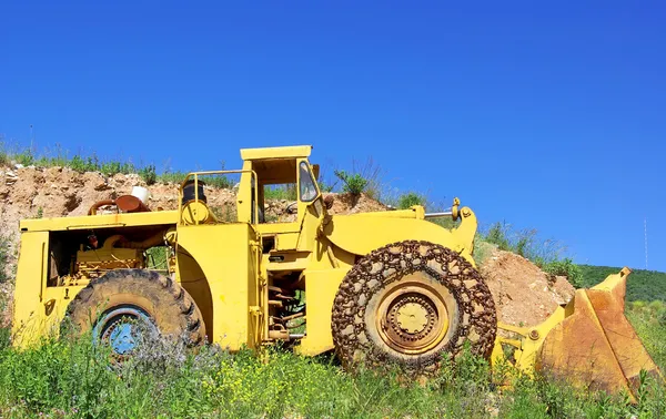 Stary żółty buldożer w pobliżu kamieniołom marmuru. — Zdjęcie stockowe