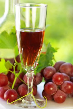 Glass of rose wine and mature grapes. clipart