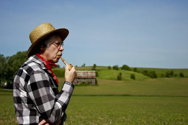 Agricultor en sombrero de paja con tubo de mazorca de maíz — Foto de Stock