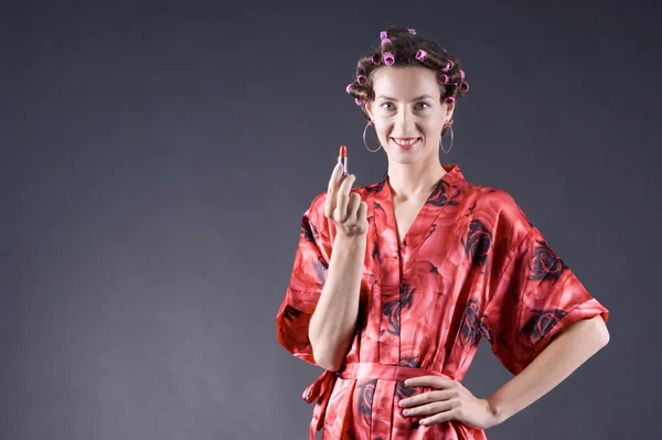 stock image Beautiful girl in a red robe home paints her lips