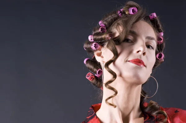 Beautiful young woman with bigoudi on the hair — Stock Photo, Image