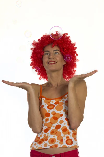 Mulher bonita em uma peruca laranja com bolhas de sabão — Fotografia de Stock