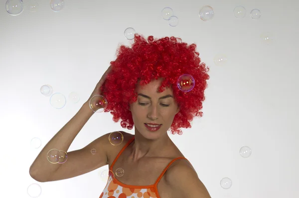 石鹸の泡でオレンジかつらで美しい女性 — ストック写真