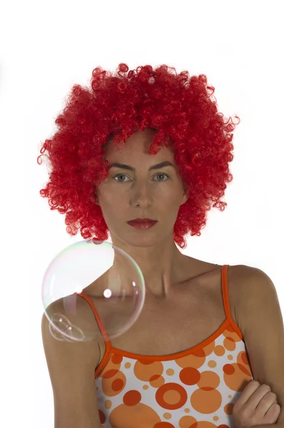 Schöne Frau in orangefarbener Perücke mit Seifenblasen — Stockfoto