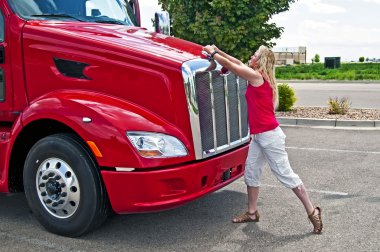 Pretty blonde woman opening a truck hood. clipart