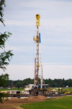 Oil rig in a cornfield clipart