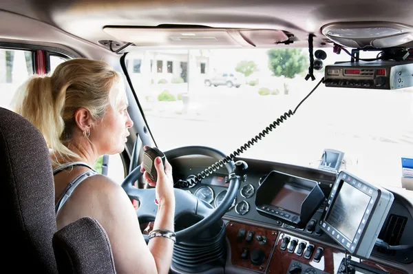 Blonde woman truck driver talking on her radio. — Stock Photo, Image