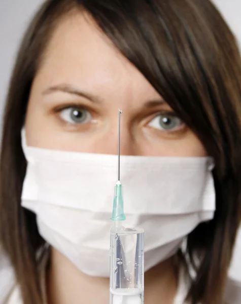 Медсестра в маске со шприцем — стоковое фото