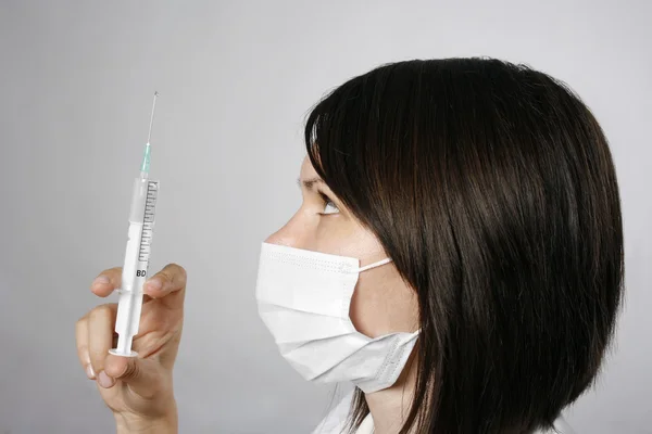 Zdravotní sestra v masce s injekční stříkačkou — Stock fotografie
