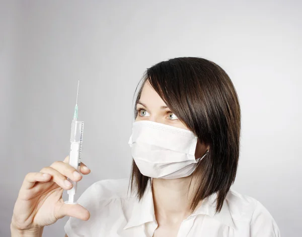 Zdravotní sestra v masce s injekční stříkačkou — Stock fotografie
