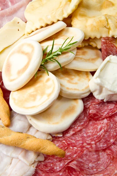 Prato de carnes curadas, queijos e bolinhos fritos — Fotografia de Stock