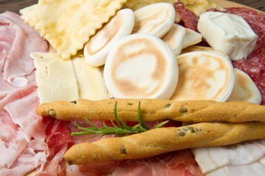 Platter of cured meats, cheeses and fried dumpling clipart