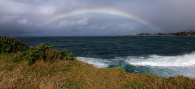 Rainbow over the ocean clipart