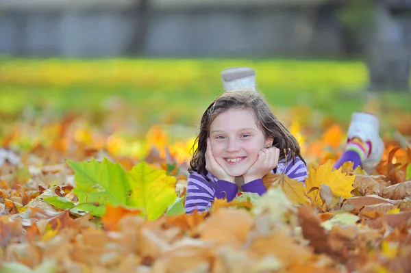 Petite fille posée sur des feuilles d'automne — Photo