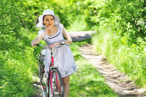Молодая женщина с винтажным велосипедом — стоковое фото