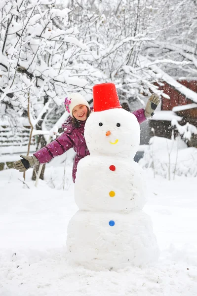 Muñeco de nieve y niña —  Fotos de Stock