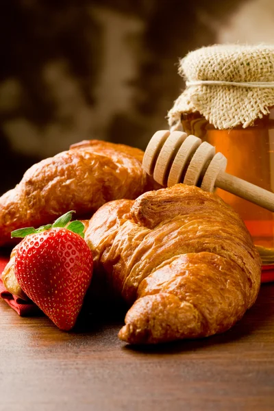 Croissanter med honung och jordgubbar — Stockfoto