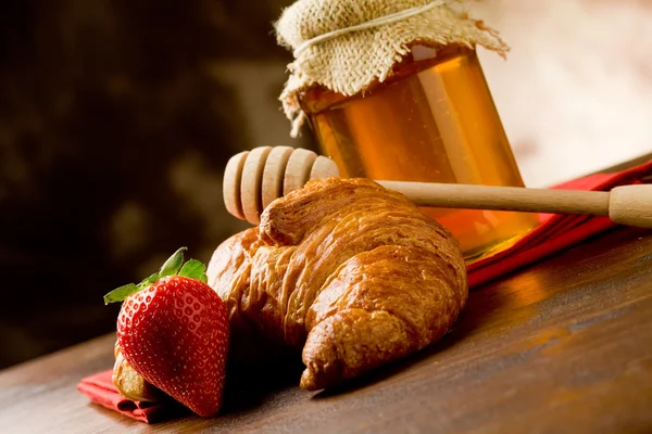 Croissants with honey and strawberries — Stock Photo, Image