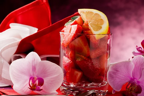 Strawberries with Orchid on red table — Stock Photo, Image