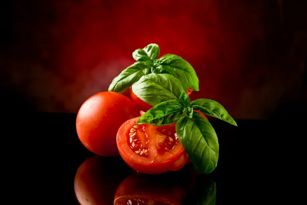 Skivade tomater med basilika på glasbord — Stockfoto
