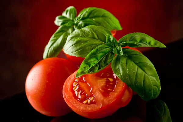 Gesneden tomaten met basilicum op glazen tafel — Stockfoto