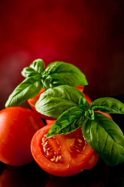 Tomates fatiados com manjericão sobre mesa de vidro — Fotografia de Stock