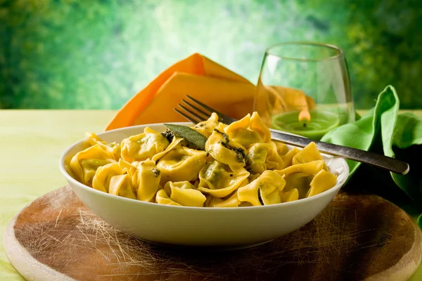 Tortellini s máslem a šalvějí se zeleným pozadím — Stock fotografie