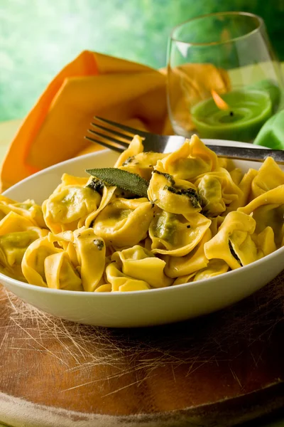 Tortellini s máslem a šalvějí se zeleným pozadím — Stock fotografie