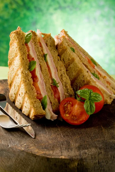 Lahodný sendvič na dřevěný stůl — Stock fotografie