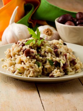 Risotto ile ahşap masa üzerinde Siyah Zeytin