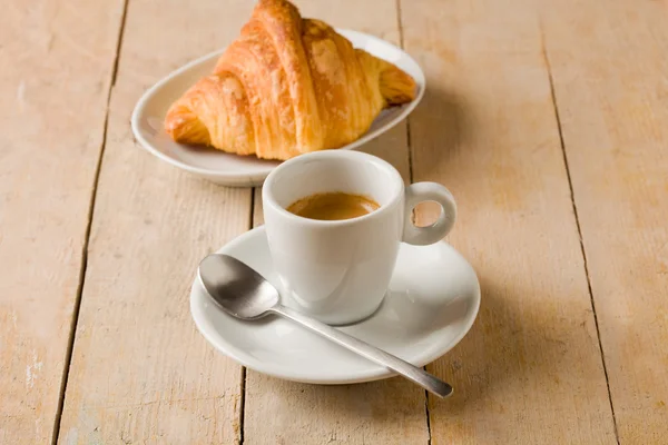 Káva a croissanty na dřevěný stůl — Stock fotografie