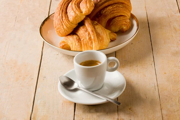 Café e croissants na mesa de madeira — Fotografia de Stock