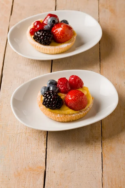 Pastry with berries on wooden table — Stock Photo, Image