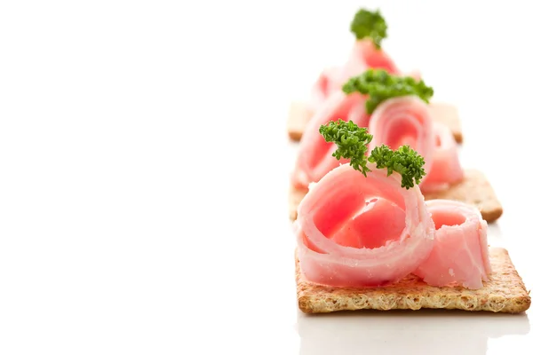 Crackers canapes with ham and parsley — Stock Photo, Image