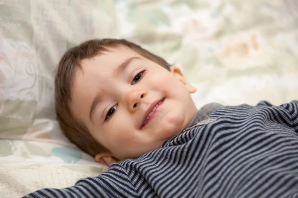 Boy lay on a bed — Stock Photo, Image