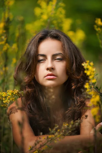 Portrait of a young woman on flowers field — Stock Photo, Image