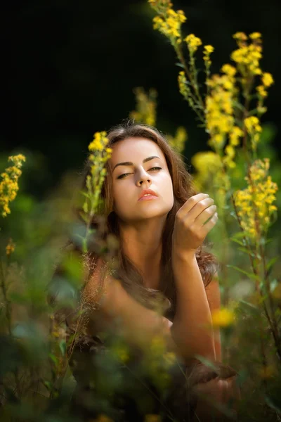 Retrato de uma jovem mulher no campo de flores — Fotografia de Stock
